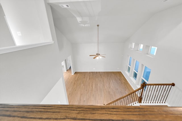 interior space with visible vents, high vaulted ceiling, stairs, and wood finished floors