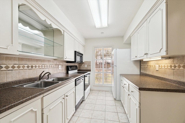 kitchen featuring electric range oven, a sink, black microwave, dishwasher, and dark countertops