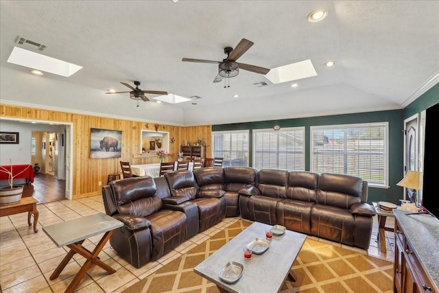 living room featuring crown molding, a healthy amount of sunlight, visible vents, and lofted ceiling with skylight