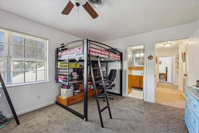 carpeted bedroom featuring ceiling fan, visible vents, baseboards, and ensuite bath