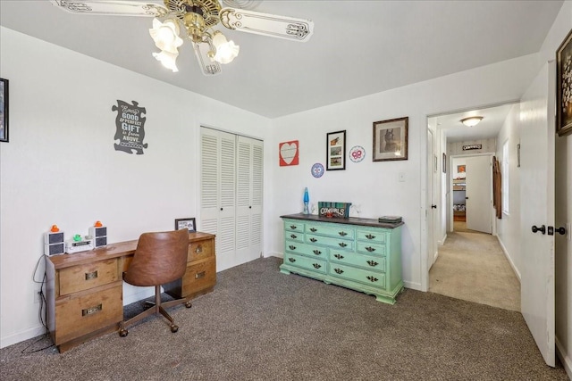 carpeted office space featuring a ceiling fan