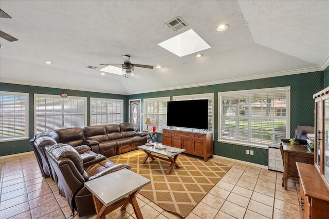 living room featuring crown molding, vaulted ceiling with skylight, visible vents, and ceiling fan