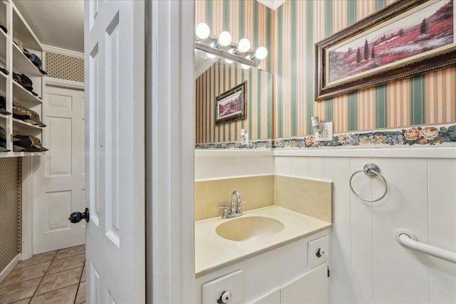 bathroom featuring tile patterned floors, wainscoting, wallpapered walls, and vanity