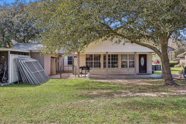 back of property featuring a yard and brick siding