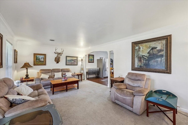 living area with arched walkways, carpet flooring, ornate columns, and ornamental molding