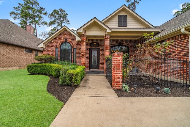 view of front of property with brick siding, roof with shingles, and a front yard