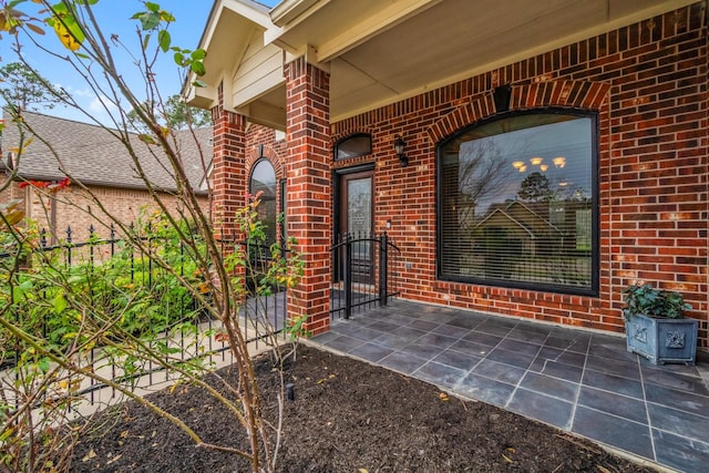 doorway to property with fence and brick siding