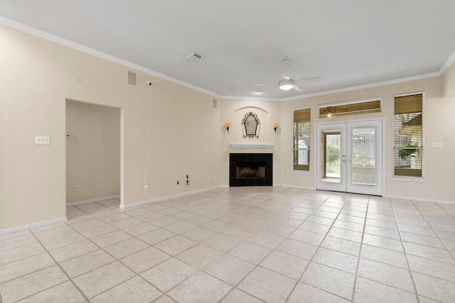 unfurnished living room with a ceiling fan, french doors, light tile patterned flooring, a fireplace, and crown molding