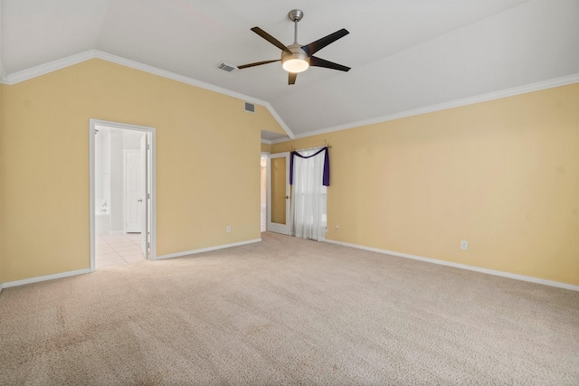 spare room featuring light colored carpet, crown molding, and vaulted ceiling