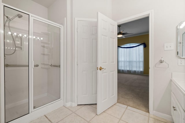 full bathroom with a shower stall, tile patterned flooring, baseboards, ceiling fan, and vanity