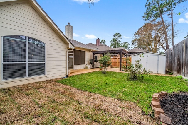 view of yard with a storage unit, a patio, an outdoor structure, and a fenced backyard