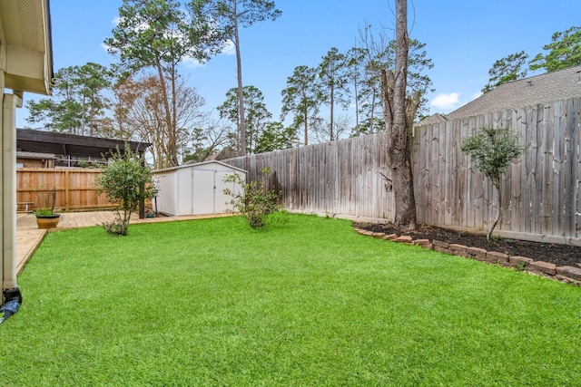 view of yard featuring a storage shed, an outdoor structure, and a fenced backyard