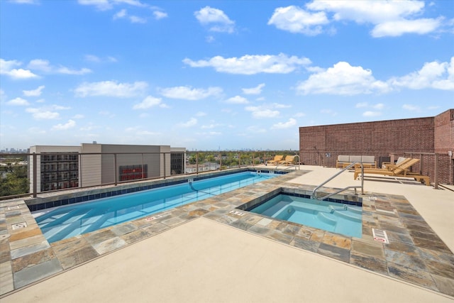 community pool with a hot tub and a patio area