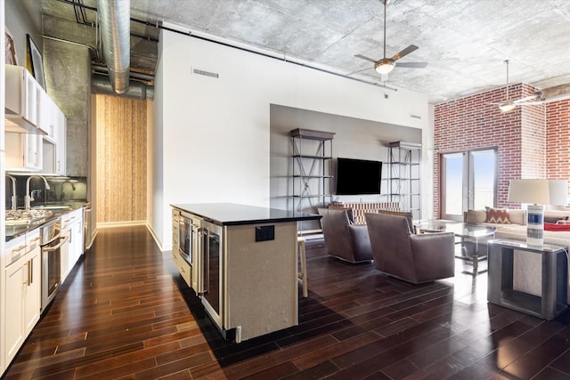 kitchen featuring a sink, dark countertops, a ceiling fan, and dark wood-style flooring