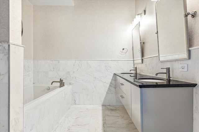 bathroom featuring a sink, wainscoting, a garden tub, and double vanity