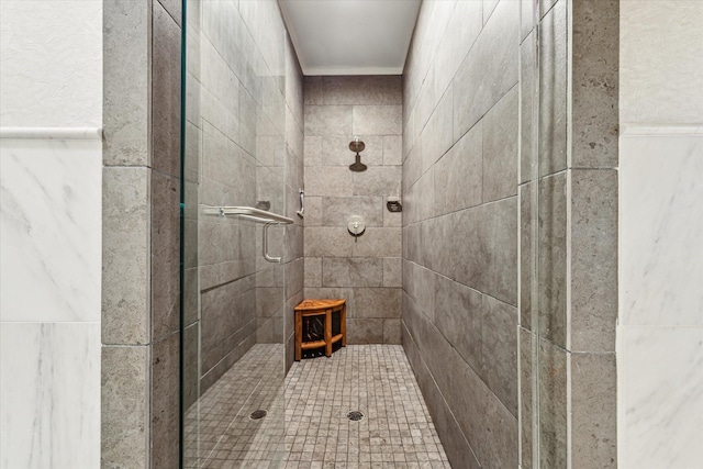bathroom featuring crown molding and a shower stall