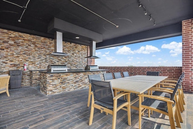 deck with outdoor dining area, a grill, and area for grilling