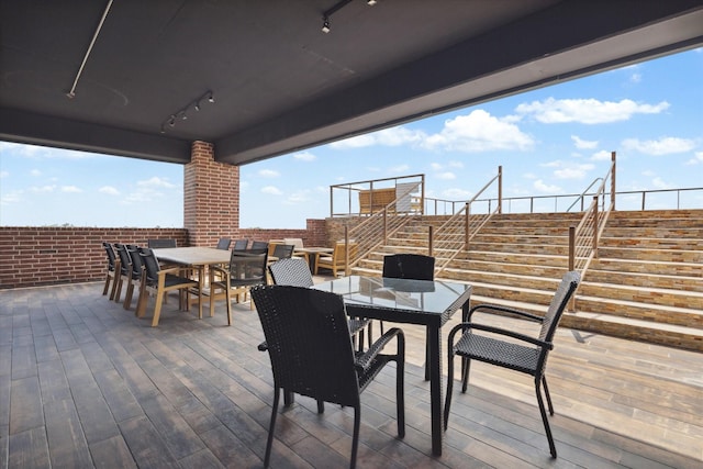 deck featuring outdoor dining area and stairway