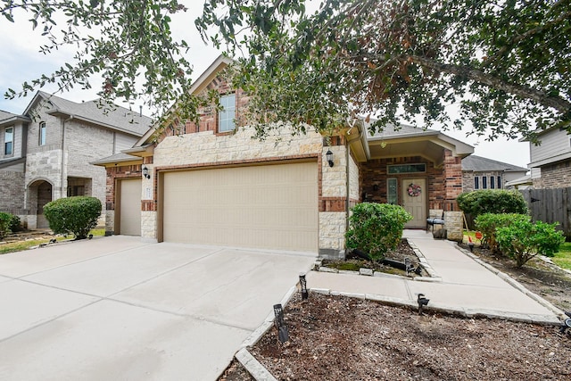 view of front of property featuring brick siding, stone siding, driveway, and fence