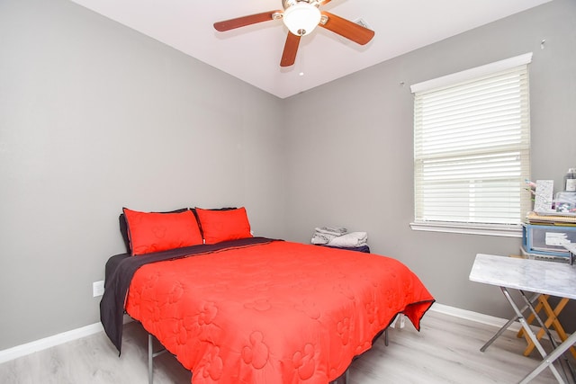 bedroom featuring baseboards, wood finished floors, and a ceiling fan