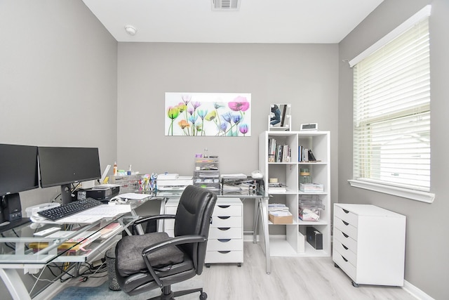 home office with visible vents, wood finished floors, and baseboards