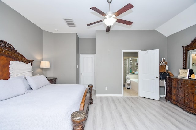 bedroom with visible vents, light wood-style flooring, ensuite bath, lofted ceiling, and ceiling fan