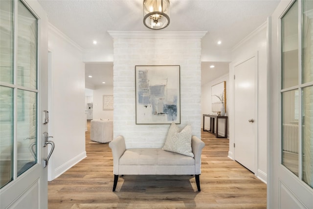 interior space with a textured ceiling, light wood-style flooring, recessed lighting, and ornamental molding