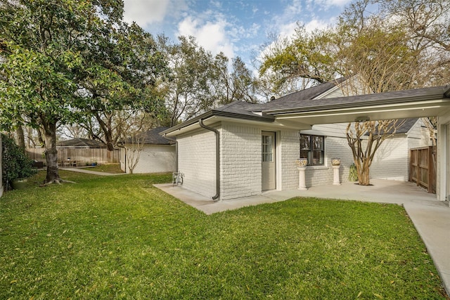 back of property featuring a patio area, a yard, fence, and brick siding