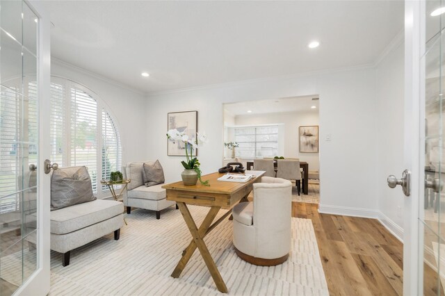 office with french doors, baseboards, crown molding, and light wood-style floors