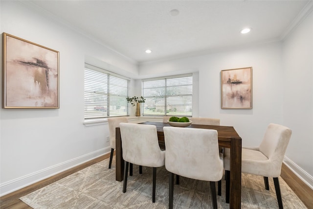 dining space with wood finished floors, baseboards, and ornamental molding