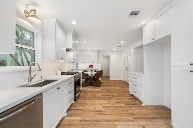 kitchen with visible vents, light wood-style flooring, a sink, appliances with stainless steel finishes, and white cabinets