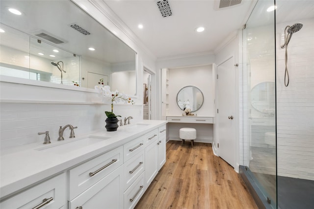 full bathroom with a sink, a stall shower, and crown molding