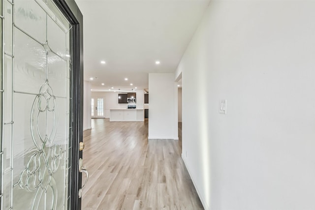 foyer featuring light wood-style flooring, recessed lighting, and baseboards