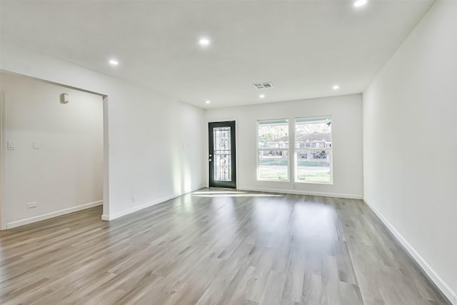 empty room featuring light wood-type flooring, visible vents, and recessed lighting