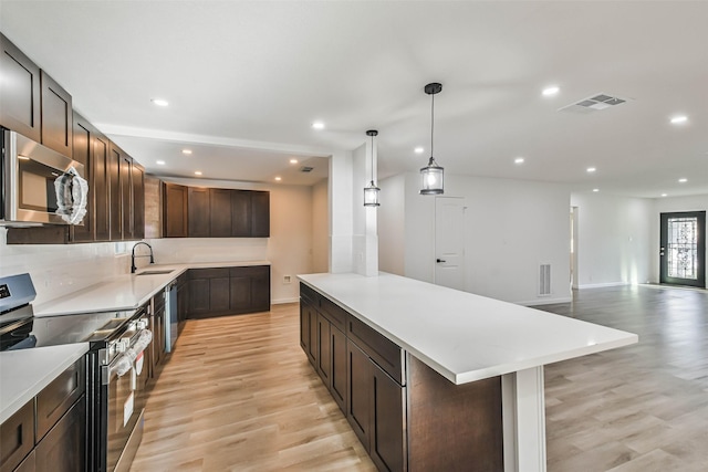 kitchen with visible vents, appliances with stainless steel finishes, light countertops, and light wood-style floors