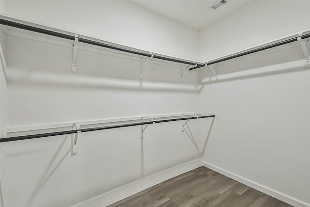 spacious closet with dark wood-type flooring and visible vents