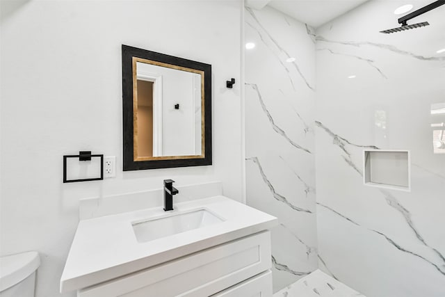 full bath featuring a marble finish shower, toilet, and vanity