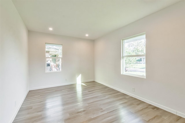 unfurnished room featuring recessed lighting, a healthy amount of sunlight, and light wood-style flooring