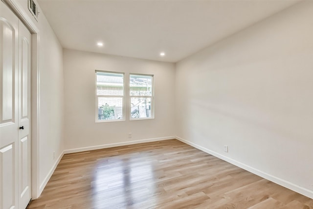 empty room featuring light wood-type flooring and baseboards