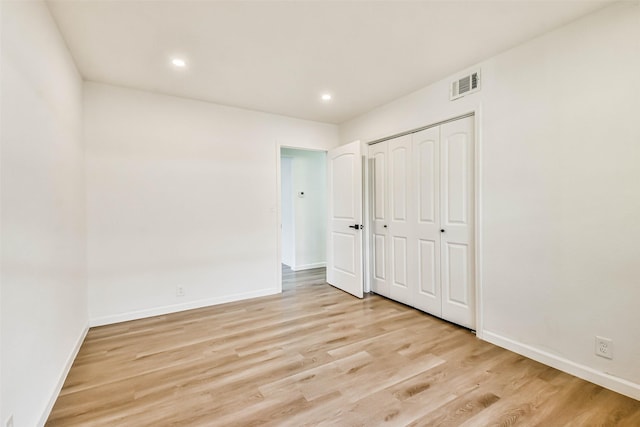 unfurnished bedroom featuring visible vents, baseboards, recessed lighting, light wood-style floors, and a closet