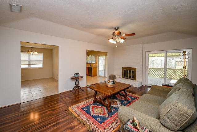 living area featuring a wealth of natural light, a fireplace, and wood finished floors