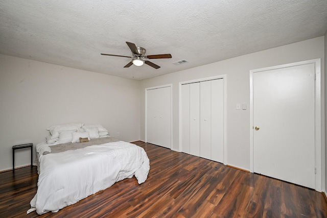 bedroom featuring a ceiling fan, wood finished floors, visible vents, and a textured ceiling