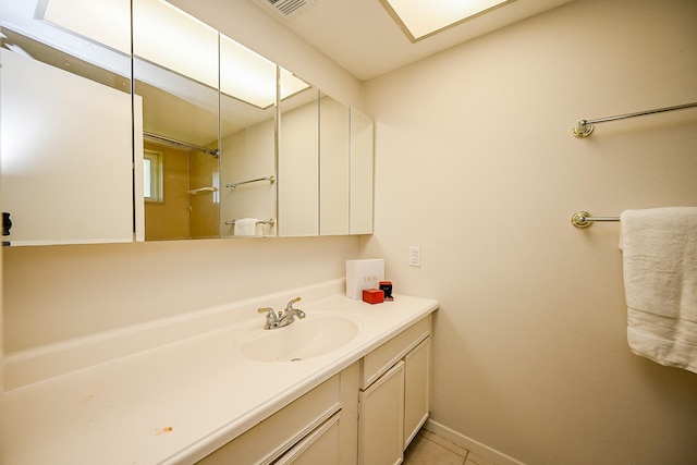 bathroom with baseboards, vanity, and tile patterned flooring