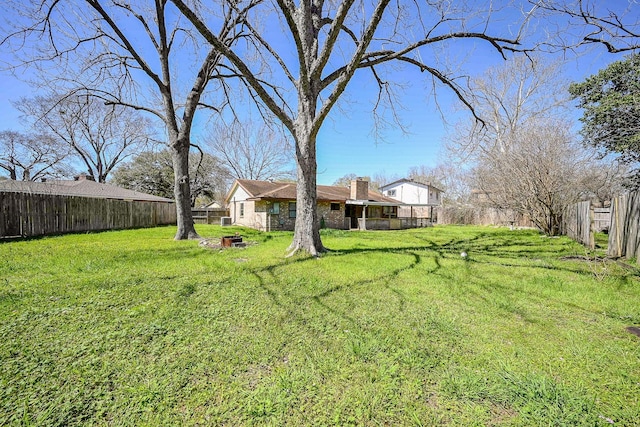 view of yard with a fire pit and a fenced backyard