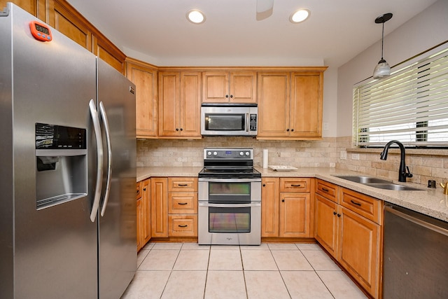 kitchen featuring backsplash, decorative light fixtures, light tile patterned floors, appliances with stainless steel finishes, and a sink