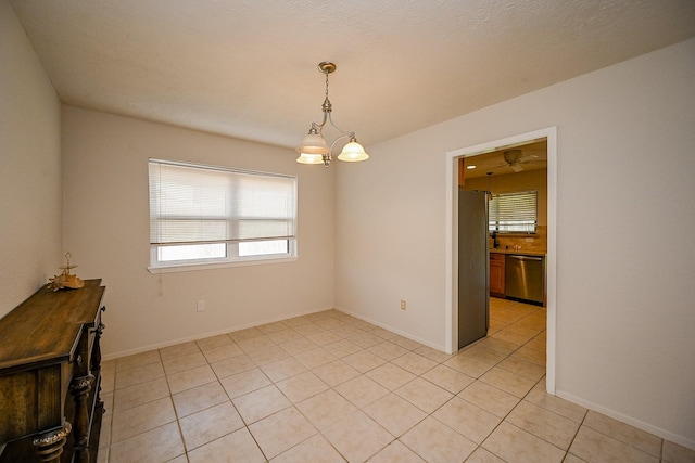 unfurnished room featuring light tile patterned floors and baseboards