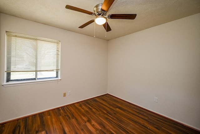 spare room with dark wood finished floors, baseboards, a textured ceiling, and a ceiling fan