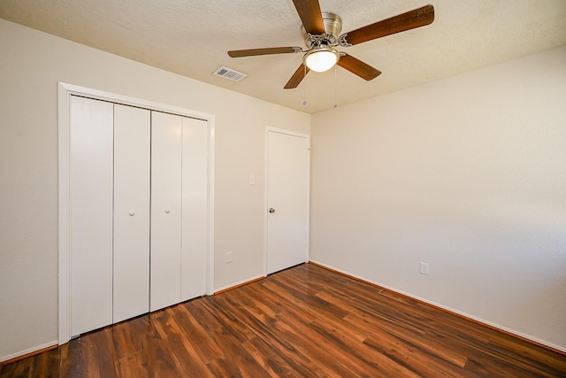 unfurnished bedroom featuring visible vents, wood finished floors, a closet, a textured ceiling, and a ceiling fan