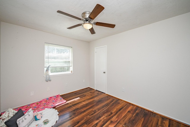 empty room featuring a textured ceiling, wood finished floors, and a ceiling fan