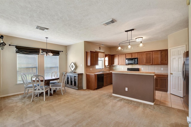 kitchen with black appliances, brown cabinetry, visible vents, and light carpet